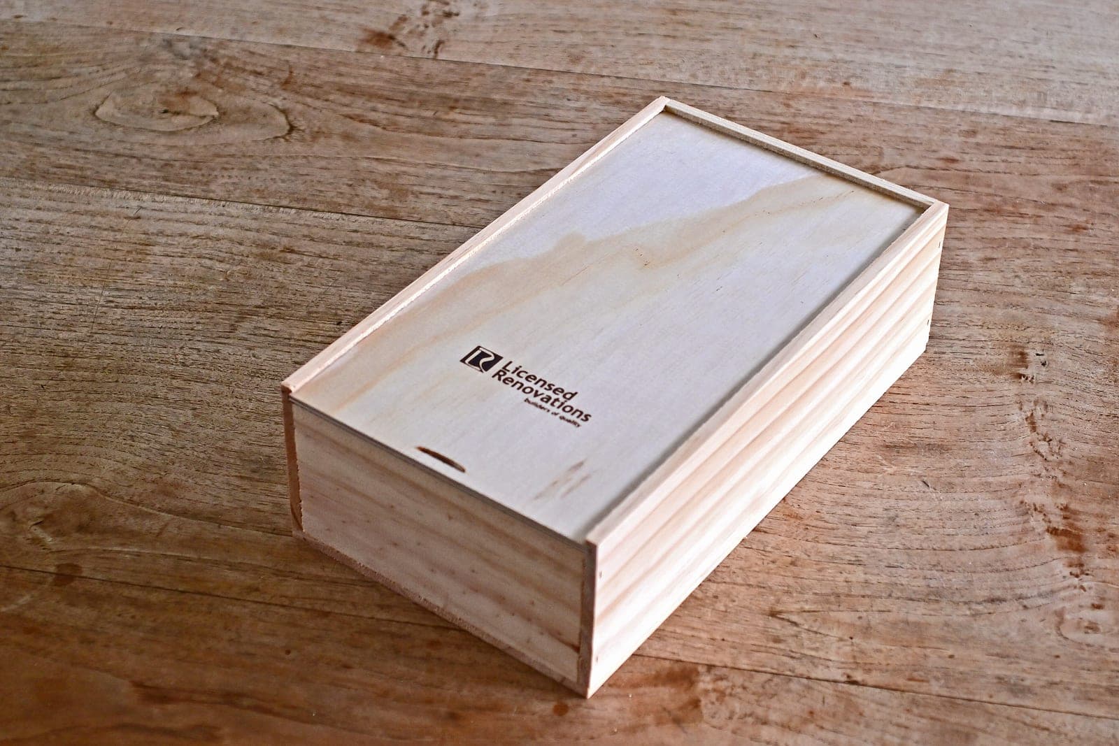 NZ-made wooden gift box with sliding lid, laser engraved with a company logo